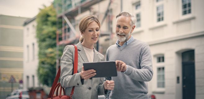 Zwei Personen blicken auf ein Tablet