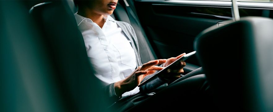 Frau mit Tablet im Auto