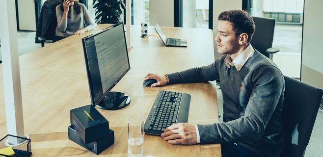 Junger Mann sitzt am Laptop