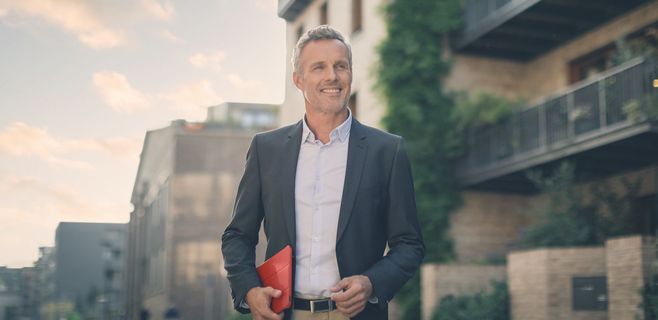 Geschäftsmann geht fröhlich durch die Stadt