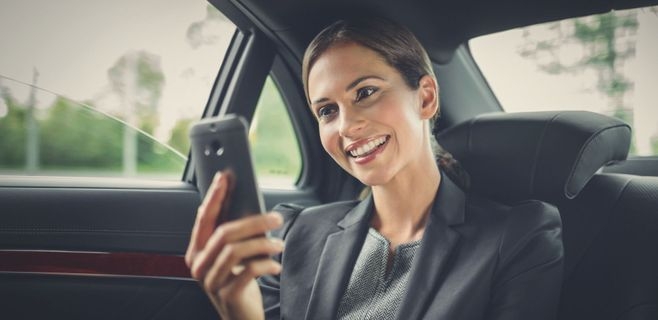 Geschäftsfrau auf dem Rücksitz eines Dienstwagens