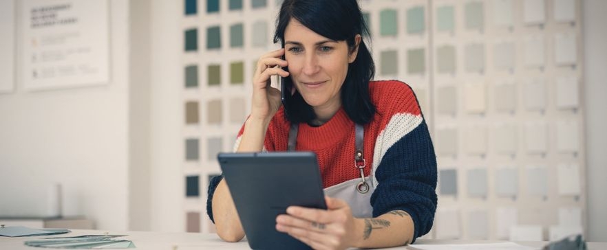Frau, die telefoniert und ihr Tablet nutzt
