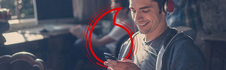 Junger Mann mit Smartphone und Kopfhörern