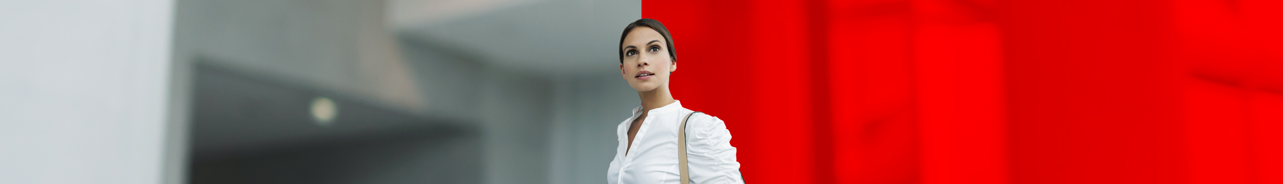 Gesch&auml;ftsfrau steht im Eingang eines B&uuml;rogeb&auml;udes