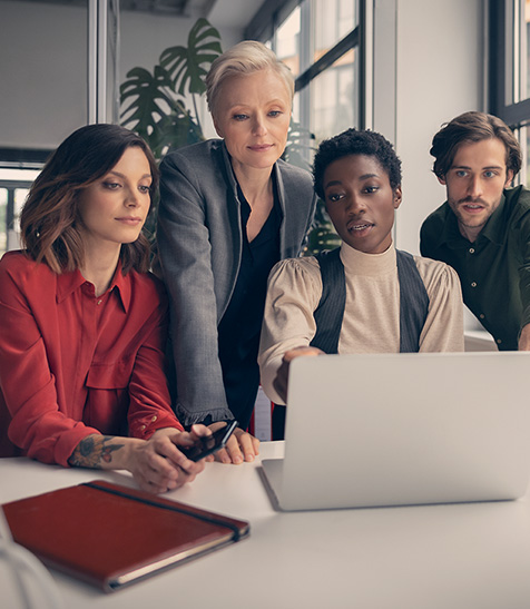 Kolleg:innen schauen auf Ergebnisse am Laptop