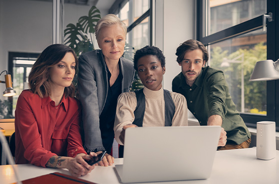 Kolleg:innen schauen auf Ergebnisse am Laptop