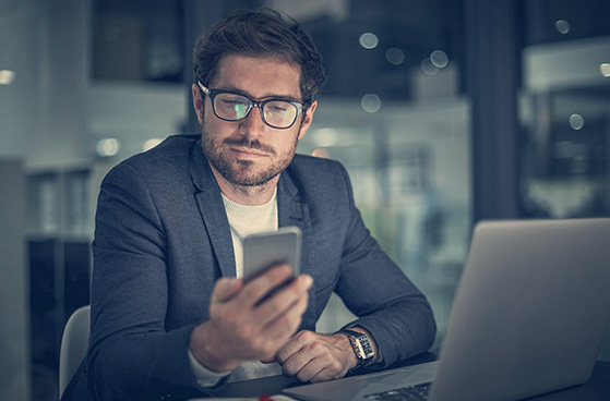 Gesch&auml;ftsmann schaut sich Anwendungen auf Smartphone an