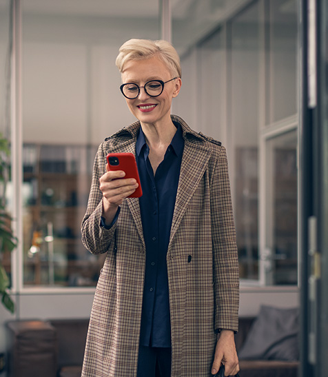 Gesch&auml;ftsfrau verschickt Nachricht auf Smartphone