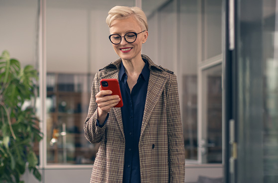 Gesch&auml;ftsfrau verschickt Nachricht auf Smartphone