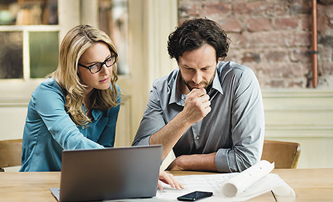 Mitarbeiter eines kleinen Unternehmens sitzen am Tisch und planen.