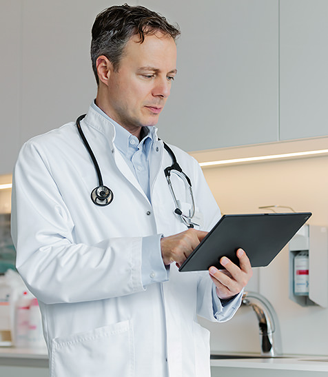 Arzt betrachtet Daten auf  dem Tablet