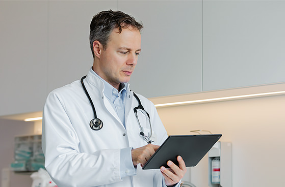 Arzt betrachtet Daten auf  dem Tablet