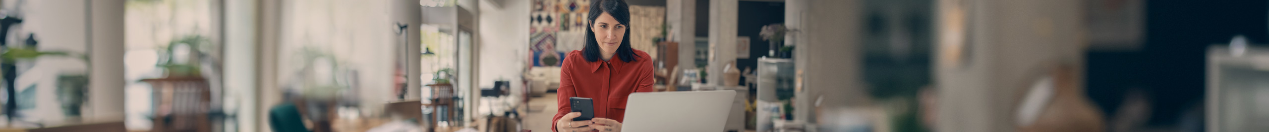 Eine Frau sitzt im Gro&szlig;raumb&uuml;ro vor ihrem Desktop.