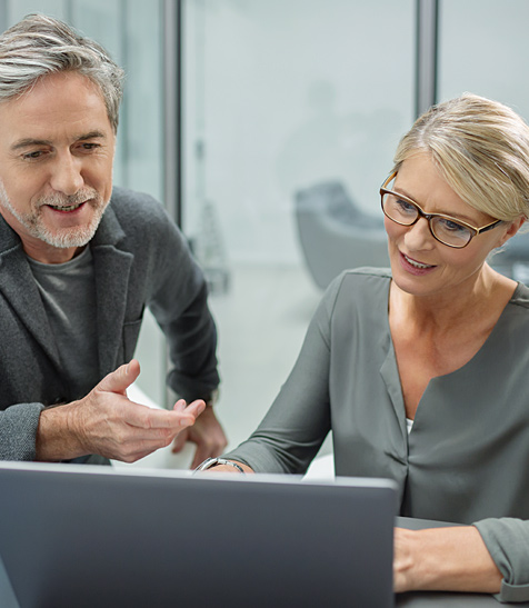 Ein Mann und eine Frau gucken zusammen auf den Laptop.