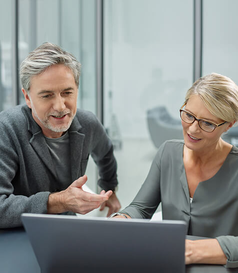 Business-Partner schauen auf Laptop