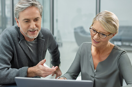 Business-Partner schauen auf Laptop