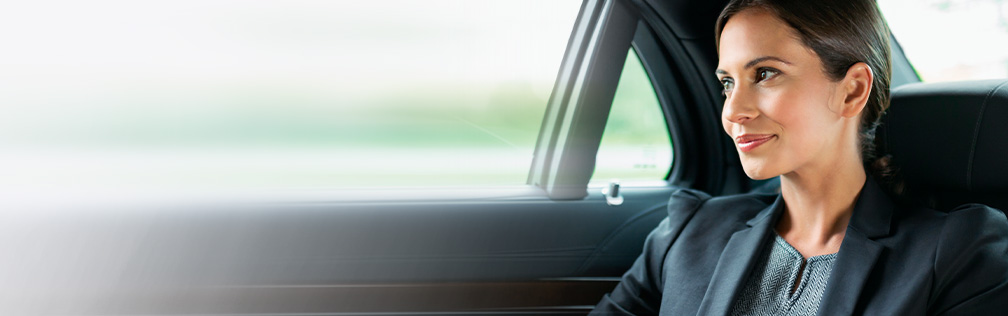 Gesch&auml;ftsfrau sitzt im Auto und schaut aus dem Fenster