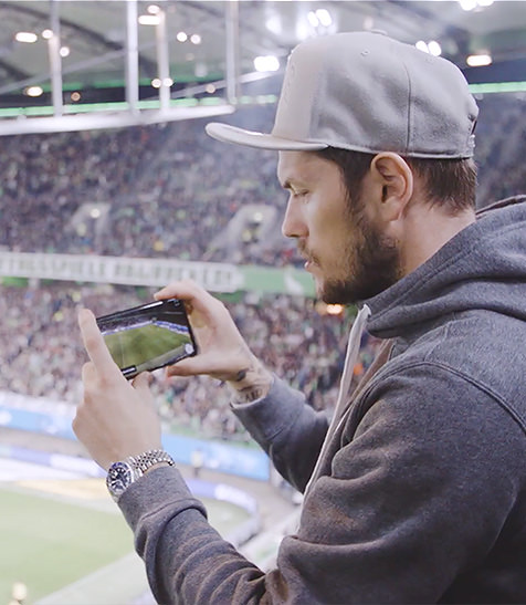 Junger Mann macht Foto in Fussballstation