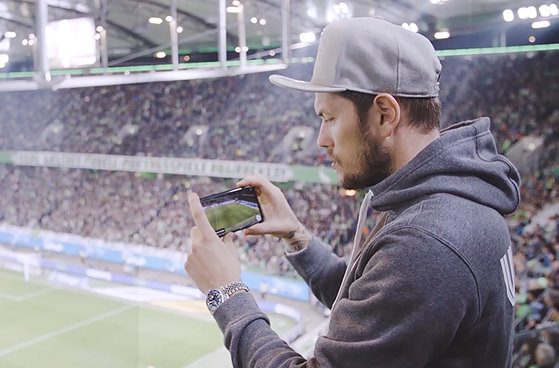 Junger Mann macht Foto in Fussballstation