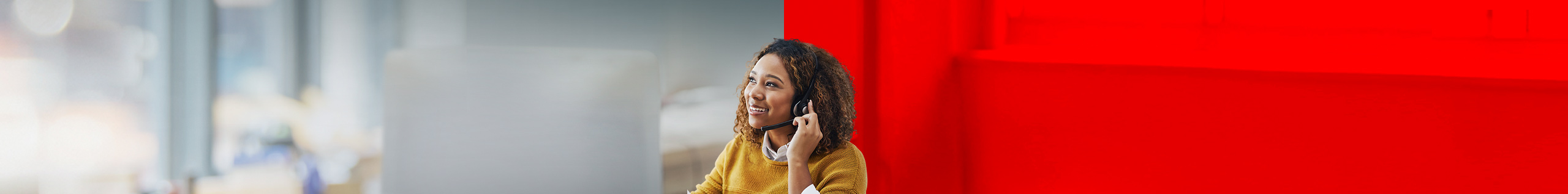Frau am PC telefoniert &uuml;ber ihr Headset.