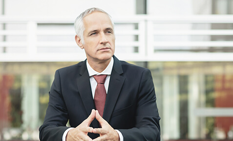 Nachdenklicher Gesch&auml;ftsmann sitzend, im Anzug