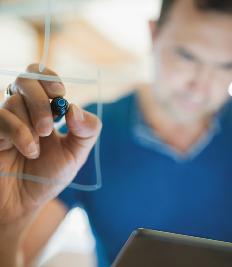 Mann schreibt L&ouml;sungs-Ideen auf eine Scheibe. 