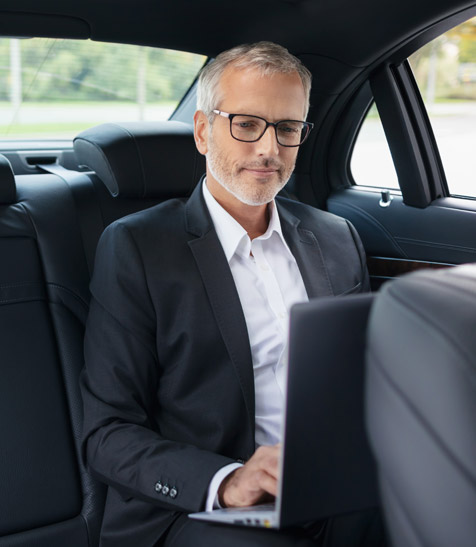 Gesch&auml;ftsmann arbeitet in einer Business-Limousine am Laptop