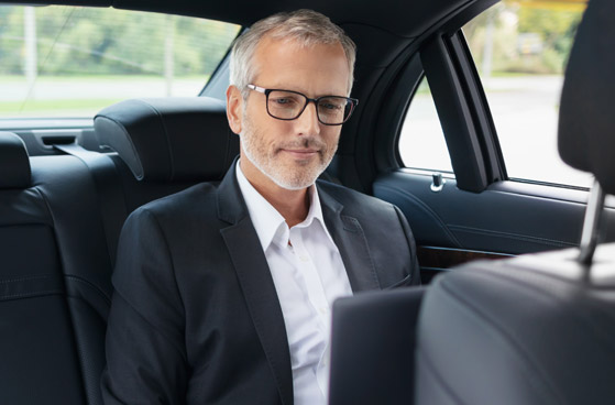 Gesch&auml;ftsmann arbeitet in einer Business-Limousine am Laptop