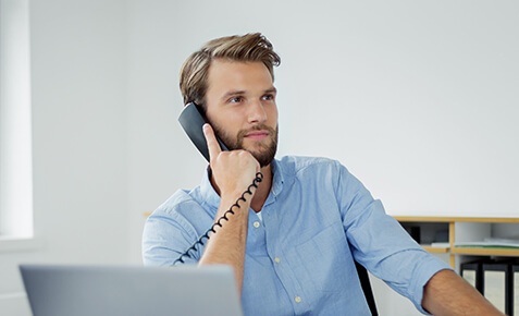 Mann telefoniert mit einer ISDN- oder IP-basierten Telefonanlage