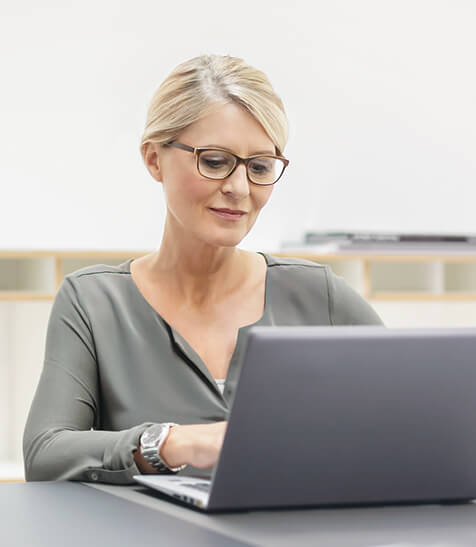 Dame sitzt an einem Laptop