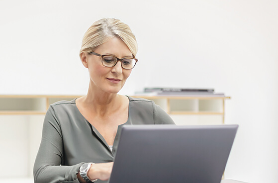 Dame sitzt an einem Laptop