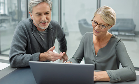 Business-Frau und ein Mitarbeiter schauen gemeinsam auf einen Laptop und nutzen flexible Datenoptionen f&uuml;r mobiles Arbeiten.