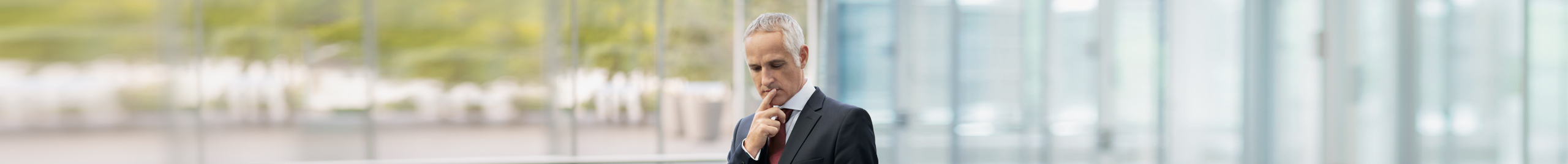 Mann im Business-Anzug liest auf Tablet