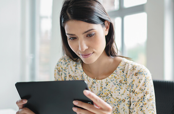Junge Dame mit Tablet registriert sich f&uuml;r das Business Partner Programm
