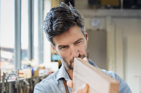 Selbst&auml;ndiger schaut &uuml;ber eine Holzlatte und m&ouml;chte seinen Red- oder Smart-Tarif verl&auml;ngern