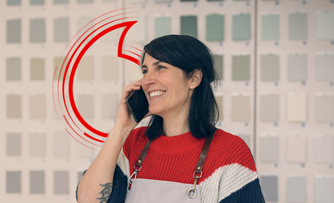 Frau steht mit Handy am Ohr am Empfang.