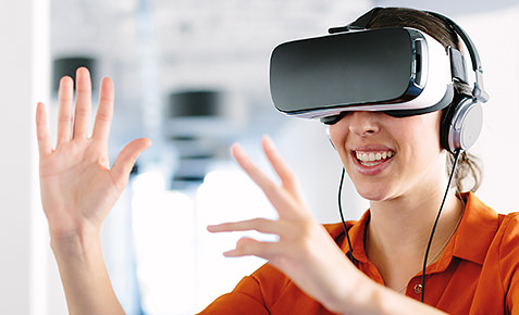 Frau mit VR-Brille und Kopfh&ouml;rern