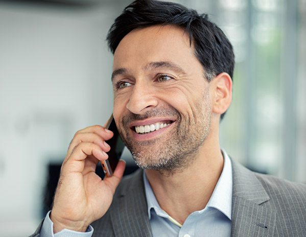 Dunkelhaariger Business-Mann telefoniert mit seinem Smartphone.