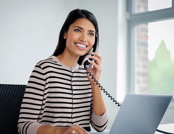 Frau im B&uuml;ro telefoniert mit einem IP-Telefon
