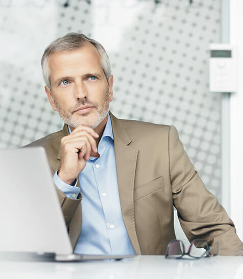 Business-Mann vor Laptop denkt &uuml;ber XRechnung nach