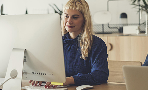 Junge Frau nutzt Cloud-Backup am Arbeitsplatz